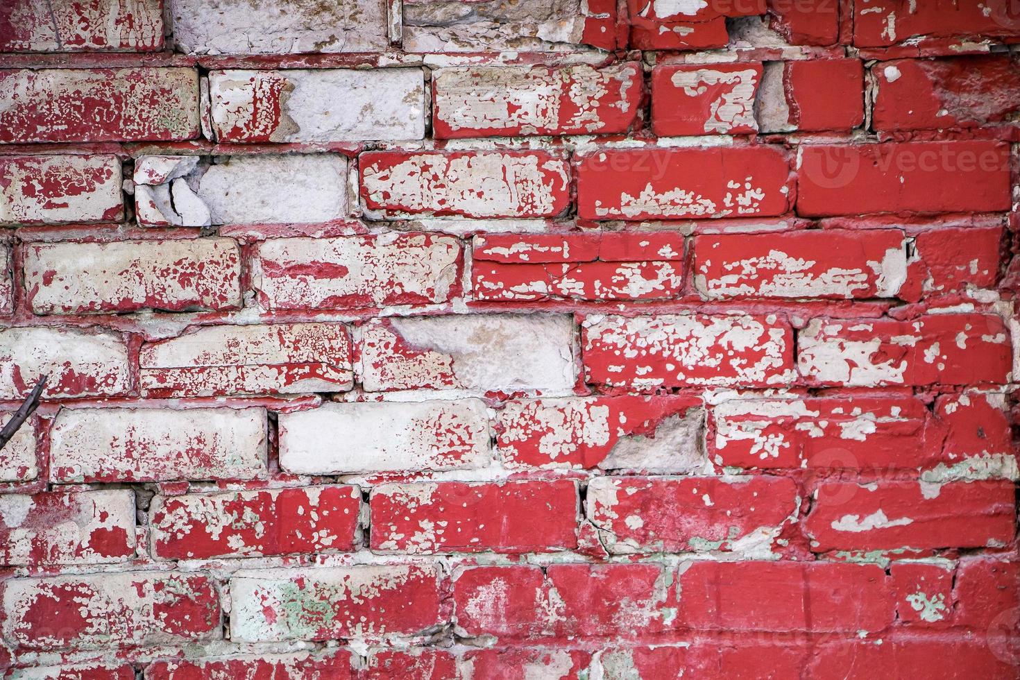 Pared de ladrillo rojo con pintura descascarada foto