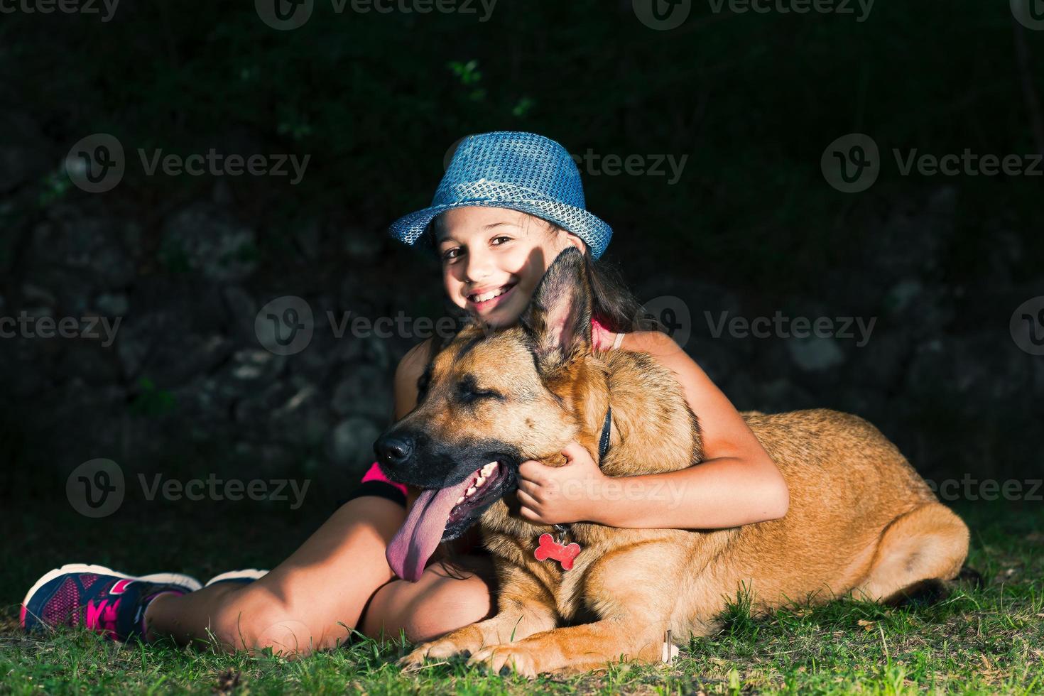 A little girl hugs her German shepherd dog photo