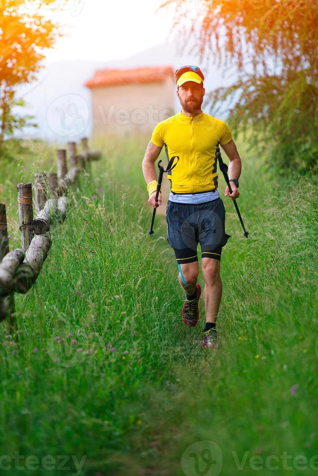 Nordic walking in the grass with sticks in hand photo