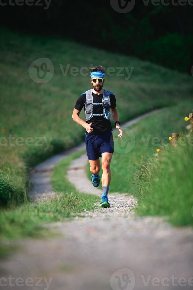 Man with beard athlete running in the mountains during a workout photo