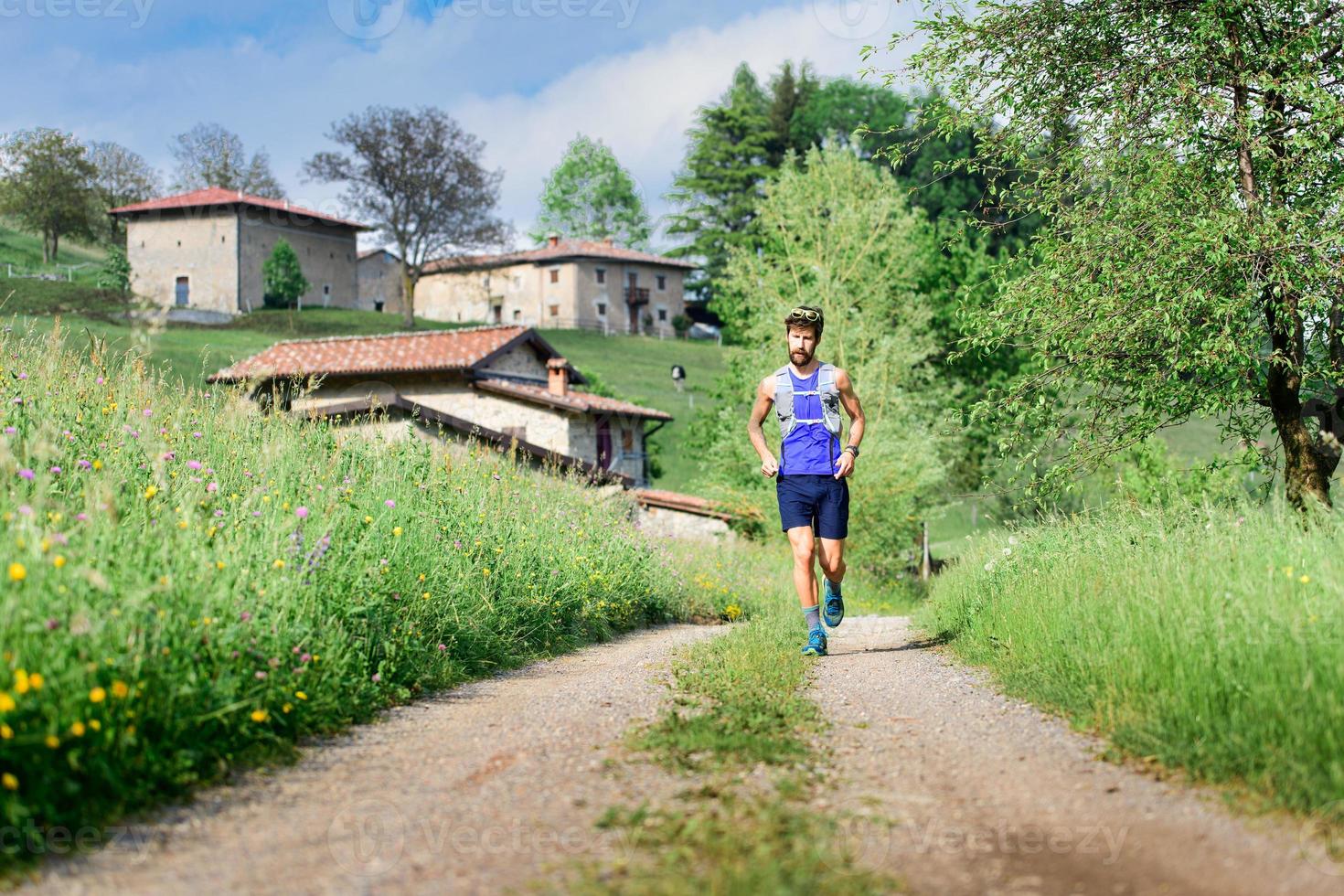 Young athlete runs in rural hill landscape photo