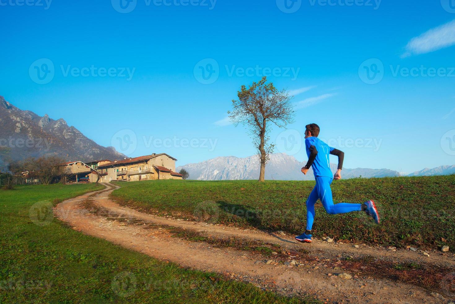 Runner athlete professional training on a mountain dirt photo
