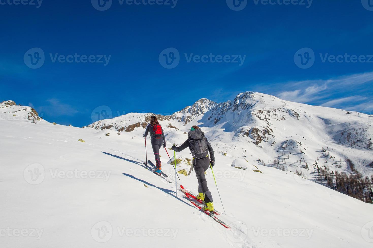A couple of women practice ski mountaineering photo