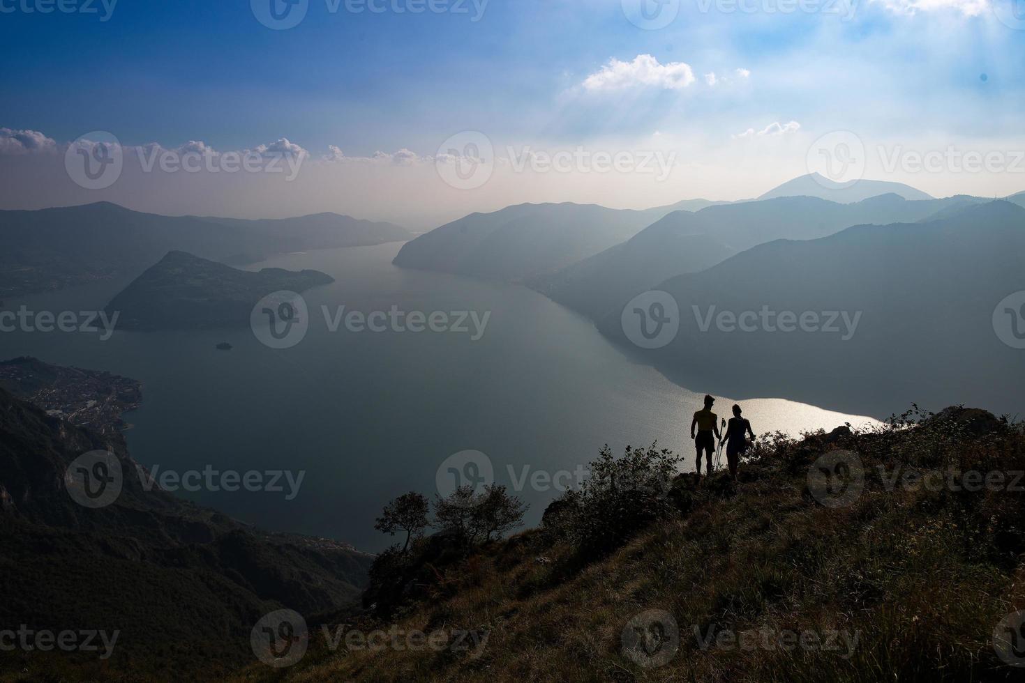 un par de excursionistas miran el panorama del lago isea en italia foto