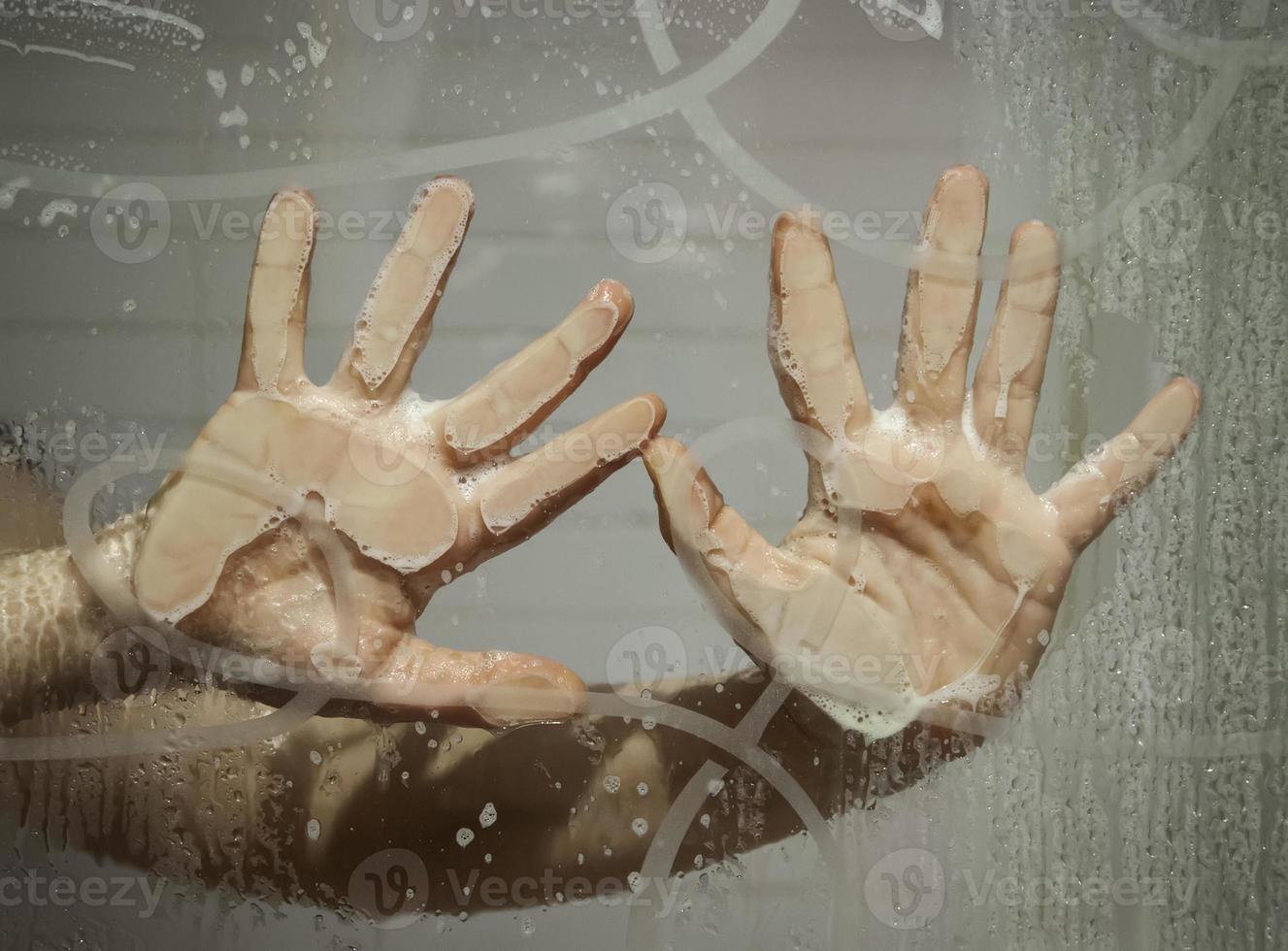 Hand on wet window photo