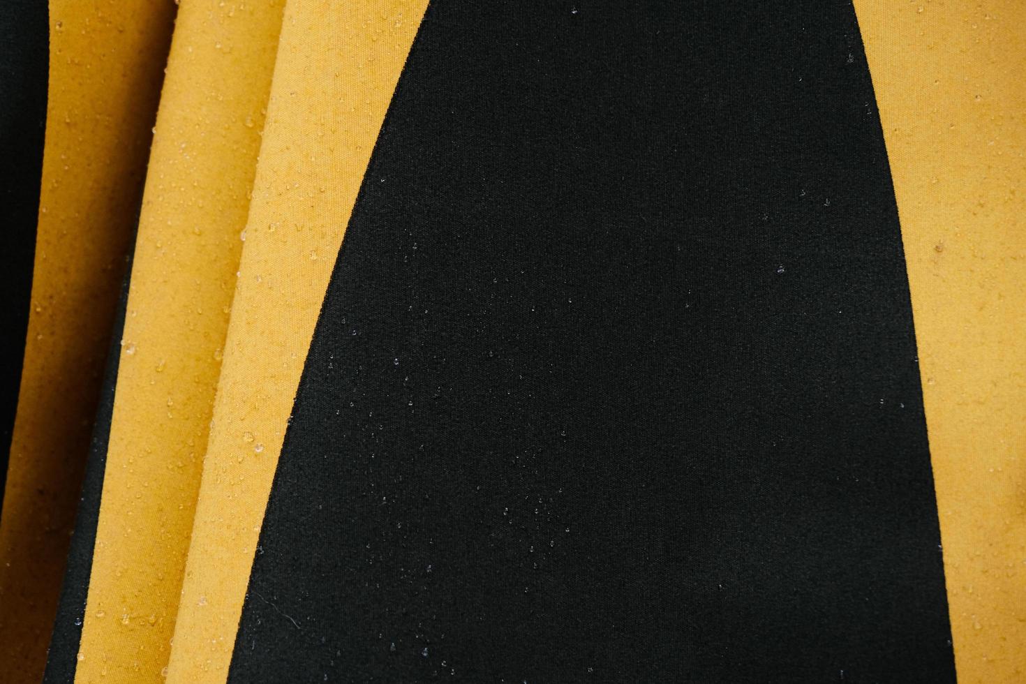Wet dark color umbrella with yellow geometric lines photo