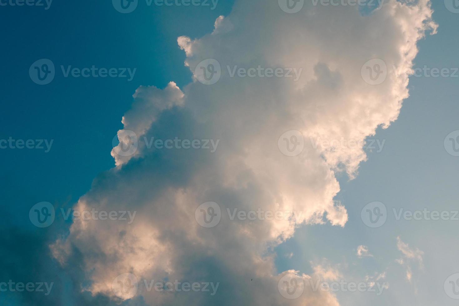 Deep blue sky and high clouds in the sun rays at sunset photo