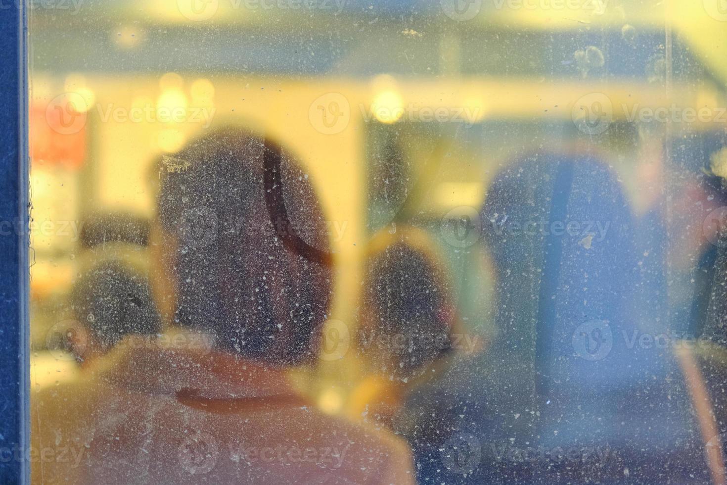 Abstract silhouettes of people standing indoors of the bakery blurred through the window photo