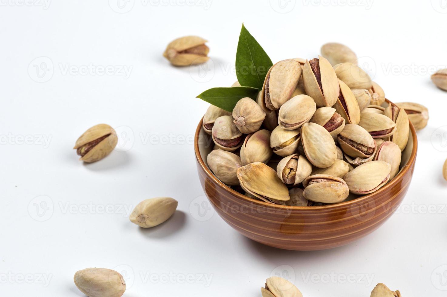 Pistacho en un tazón sobre fondo blanco. foto