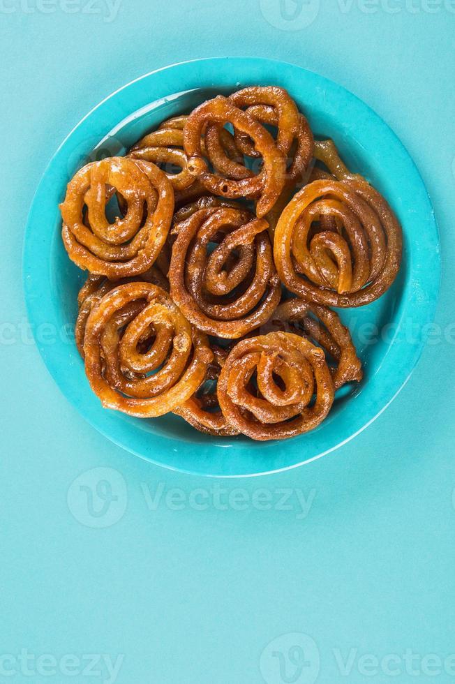 Dulce indio jalebi, postre indio jalebi o imarti o imarati o jilbi sobre fondo azul. foto