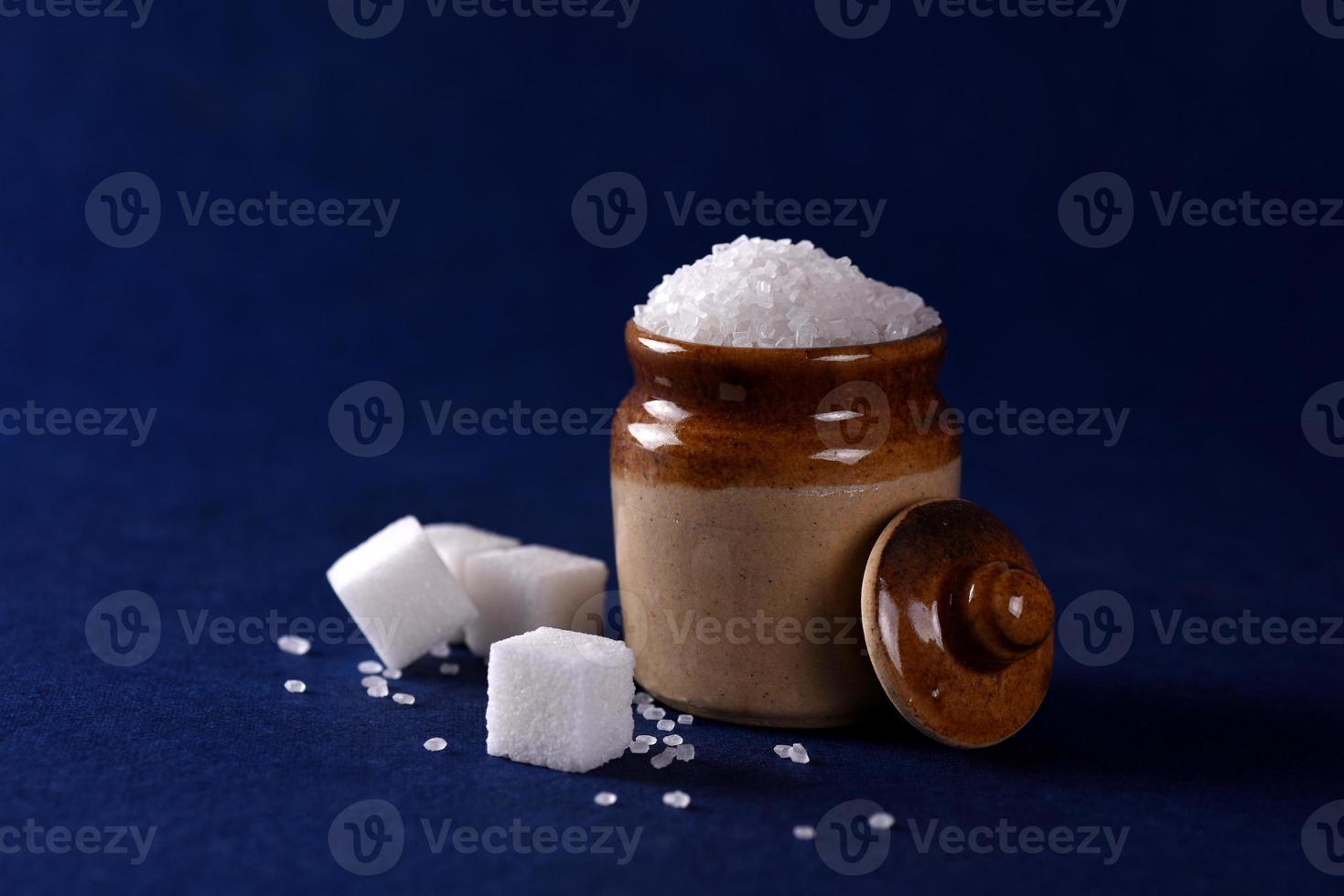 Sugar. white granulated sugar and refined sugar on a blue background photo