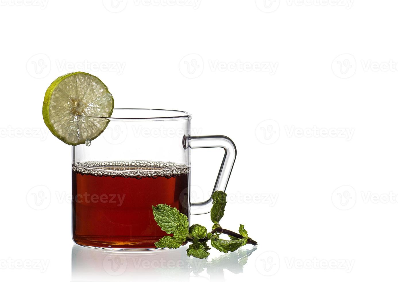 Taza de té, menta y limón sobre fondo blanco. foto