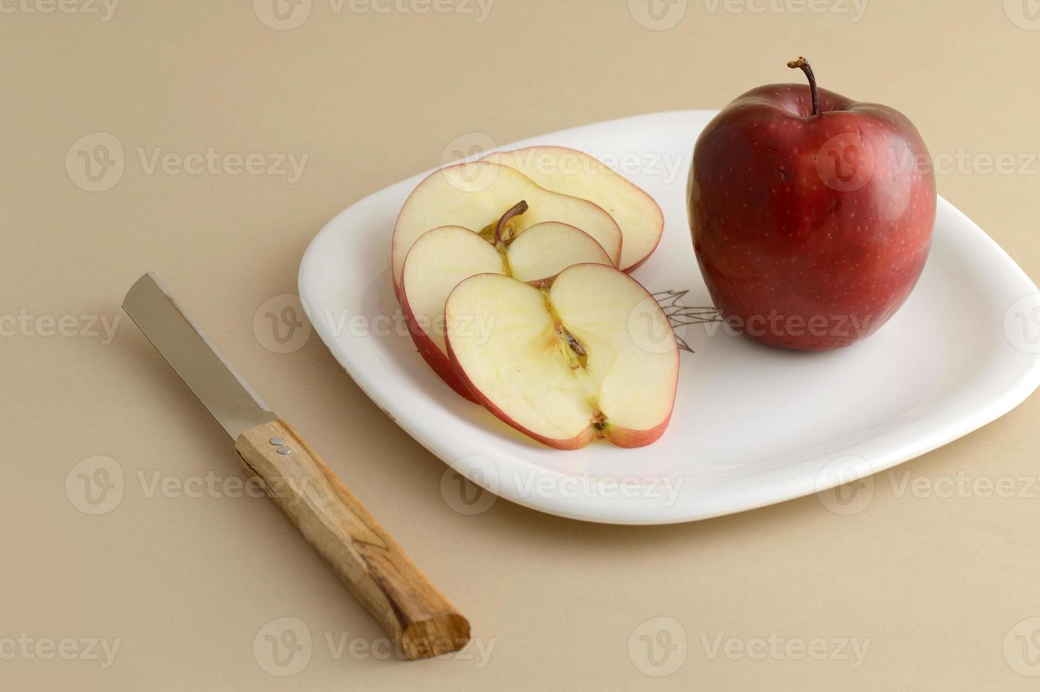 Deliciosa manzana y rebanada en plato blanco con cuchillo y tenedor foto