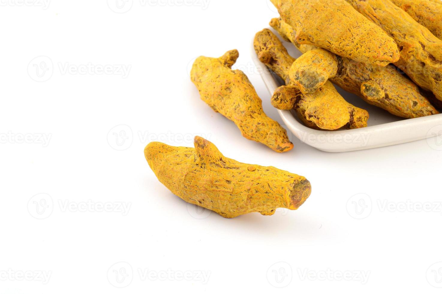 Dry Turmeric roots or barks in white plate isolated on white background photo
