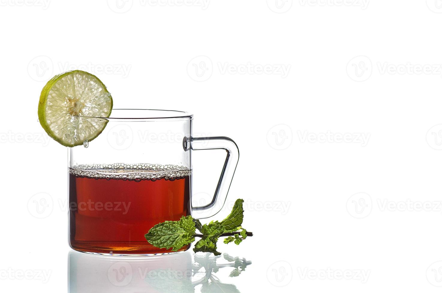 Taza de té, menta y limón sobre fondo blanco. foto