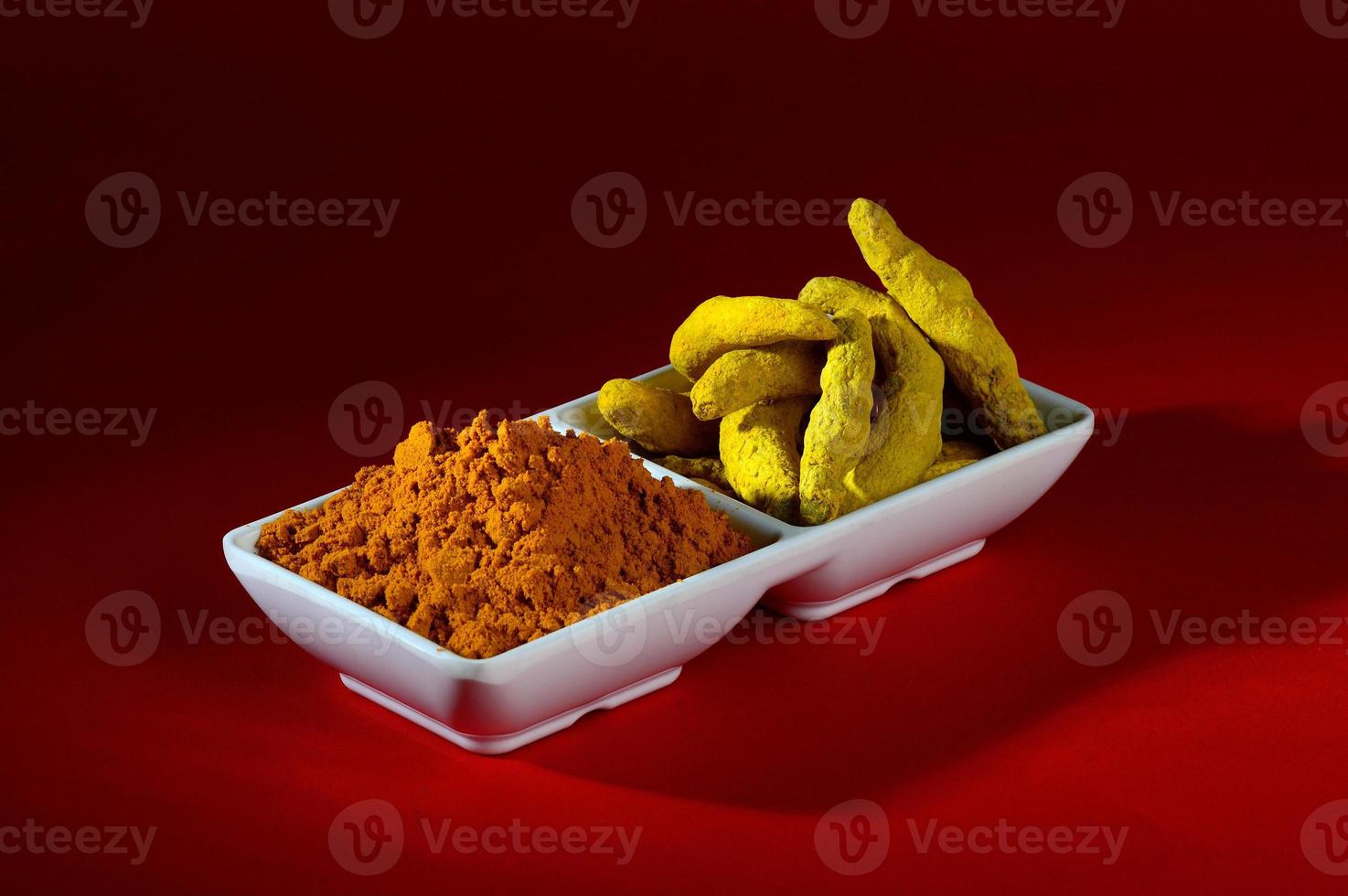 Dry Turmeric powder and roots or barks in white plate photo