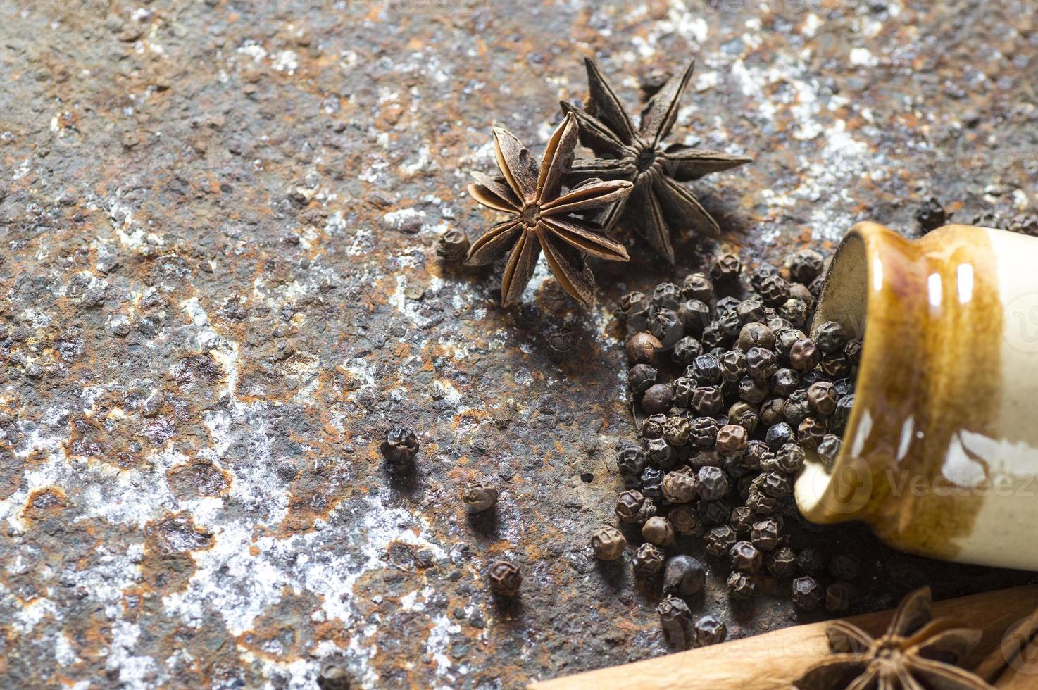 especias y hierbas. ingredientes de la comida y la cocina. palitos de canela, estrellas de anís, granos de pimienta negra sobre fondo de textura foto