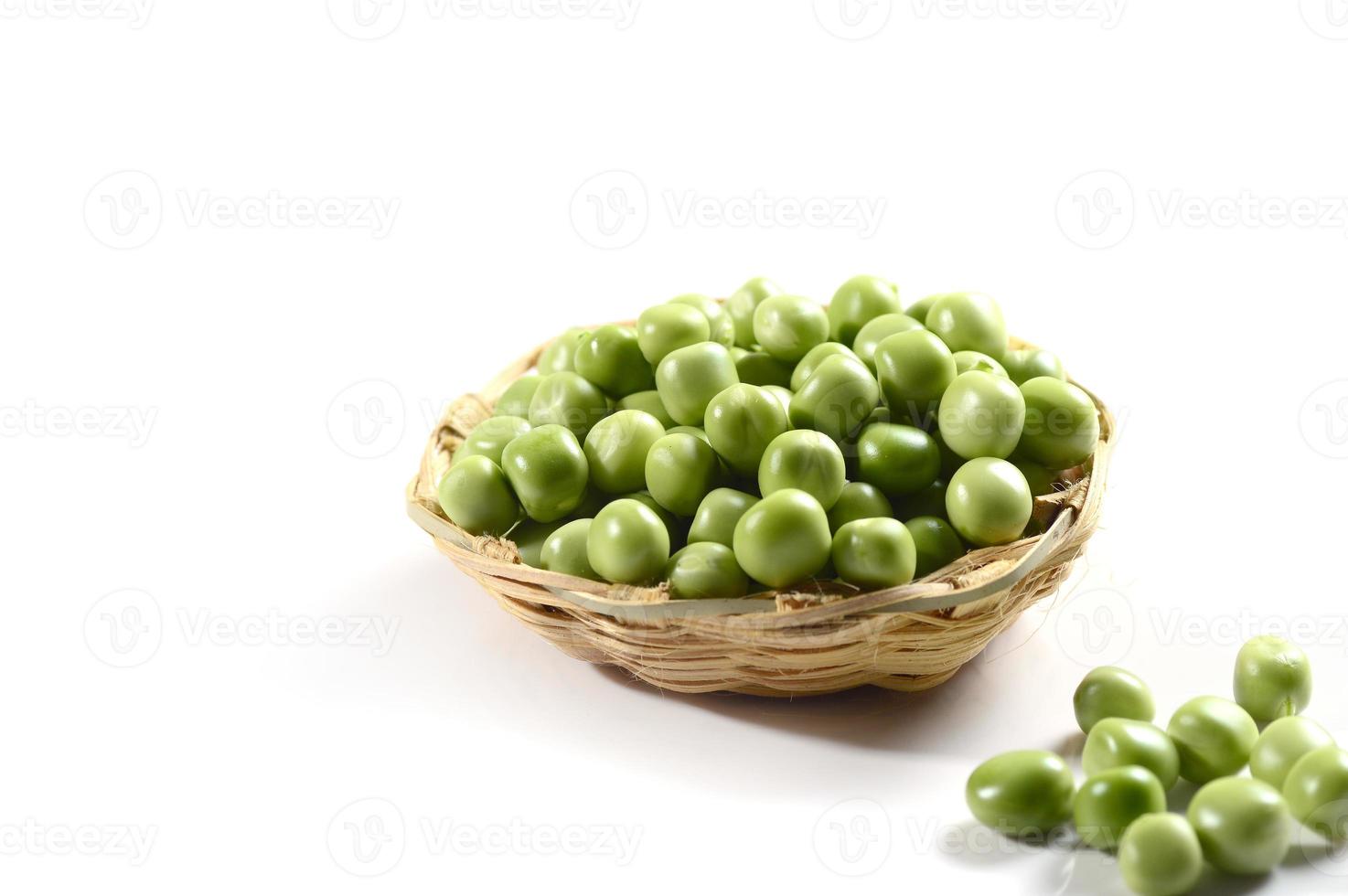 Guisantes verdes frescos en la canasta sobre fondo blanco. foto