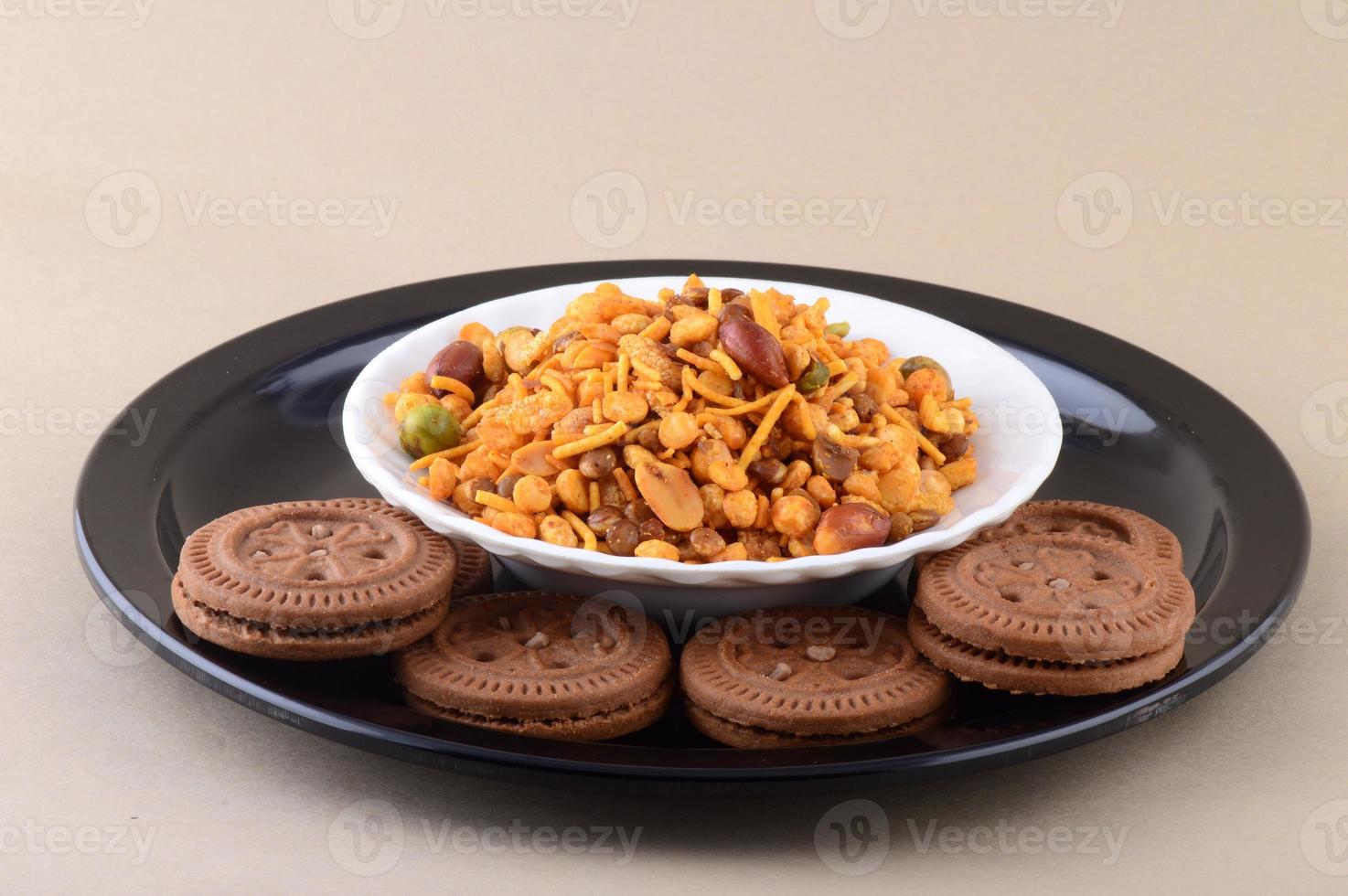 Indian snack Mixture and Cream Biscuit in plate. photo