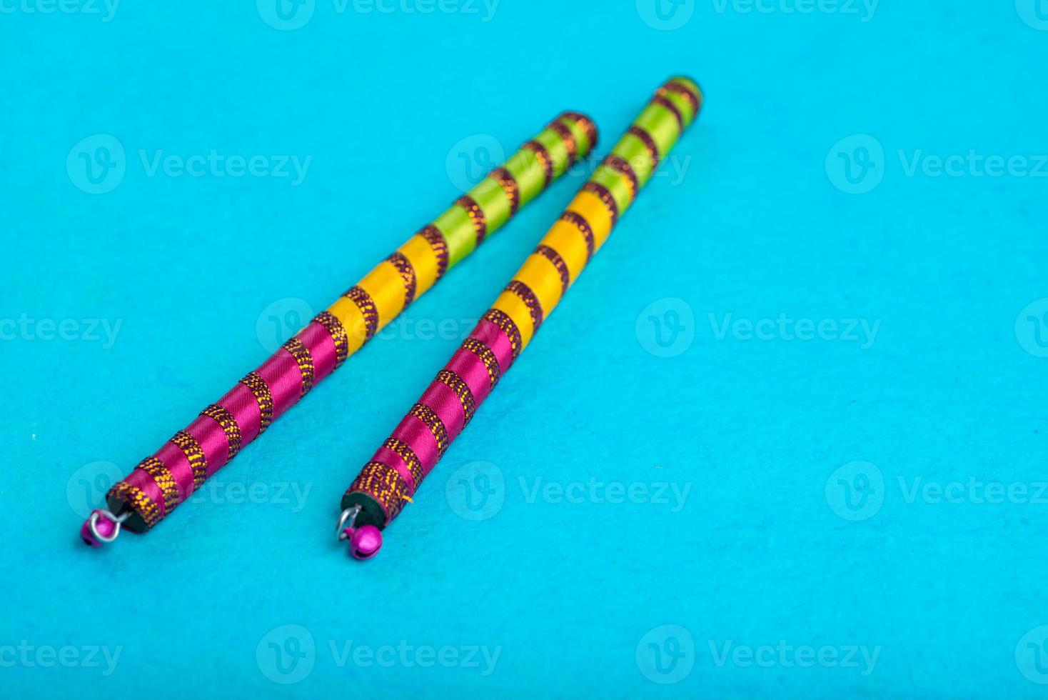 Dandiya sticks on a blue background. Raas Garba or Dandiya Raas is the traditional folk dance photo