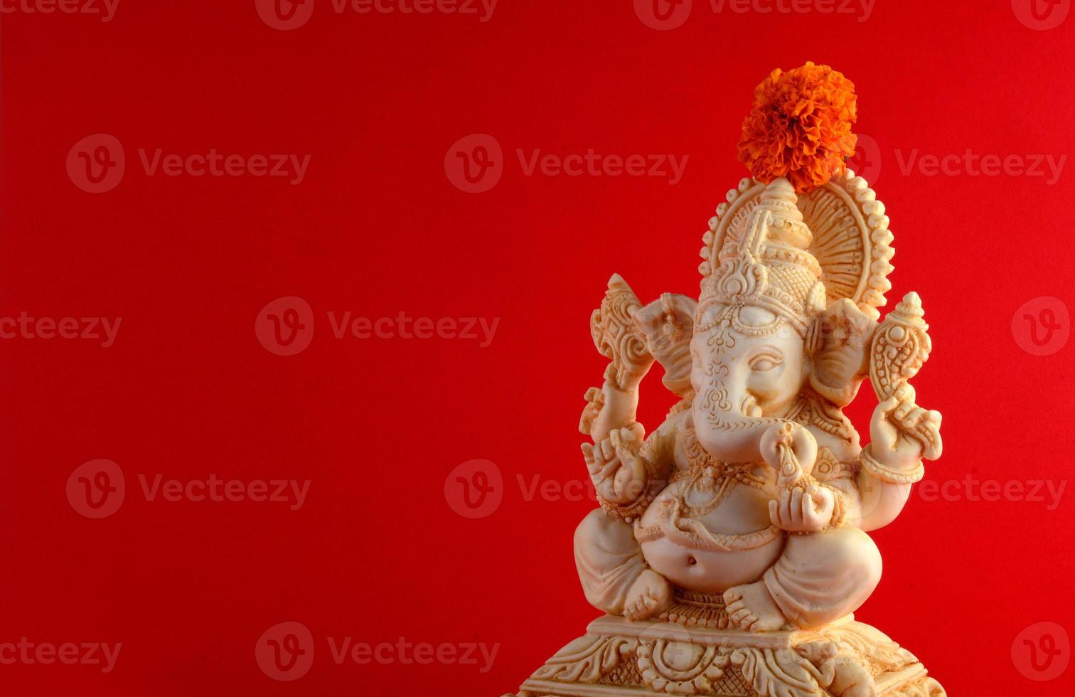 dios hindú ganesha. ídolo de ganesha sobre fondo rojo foto