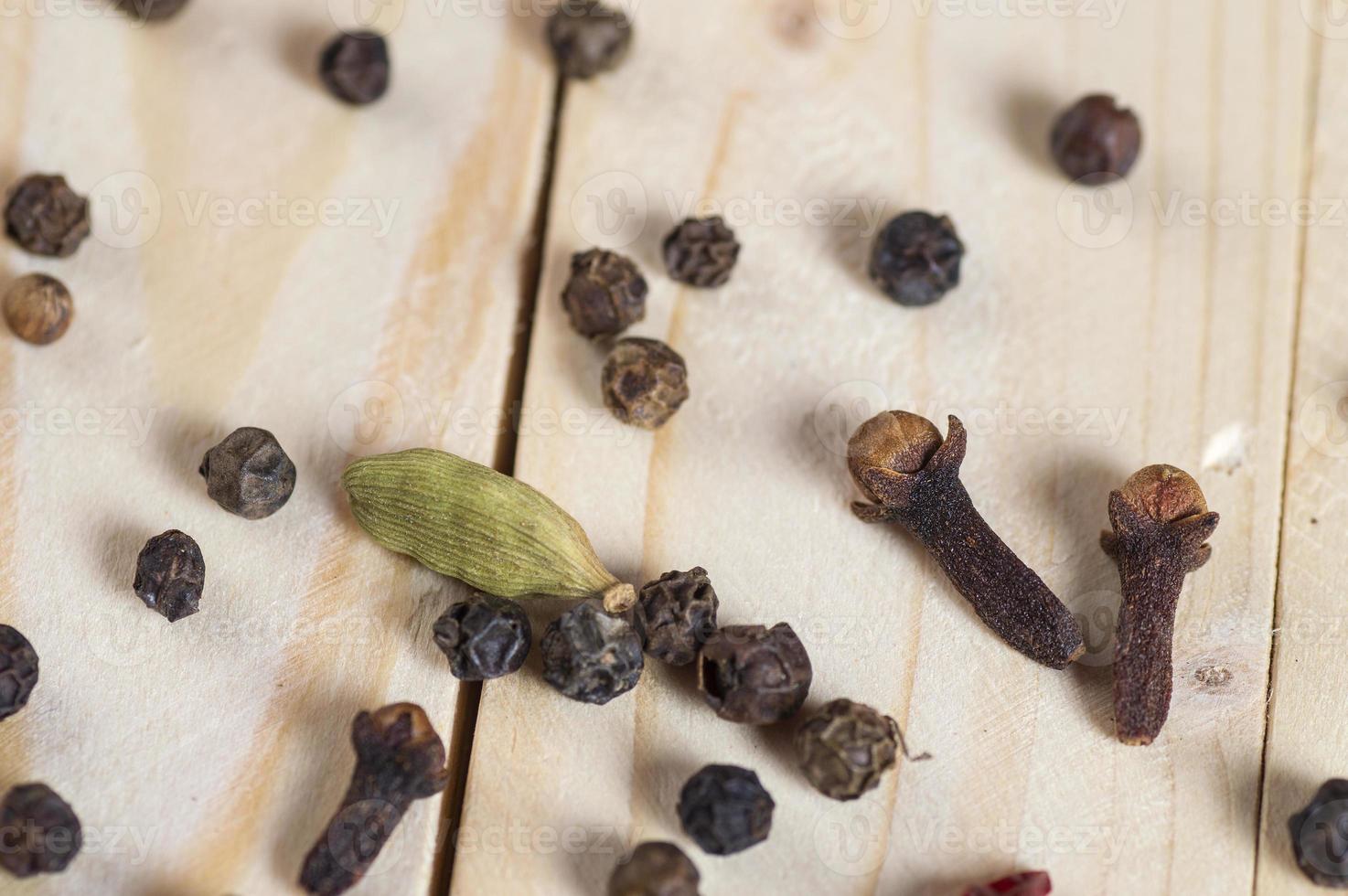 especias y hierbas. ingredientes de la comida y la cocina. Palitos de canela, estrellas de anís, pimienta negra, ají, cardamomo y clavo sobre un fondo de madera foto