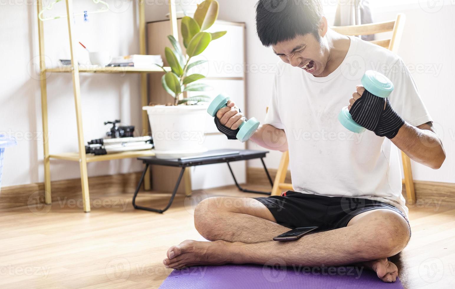Asian caucasian man holds dumbbells in home photo