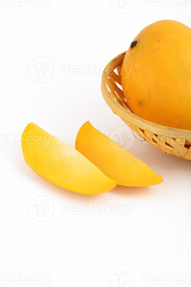 Fruta de mango en la canasta con rodaja sobre fondo blanco. foto