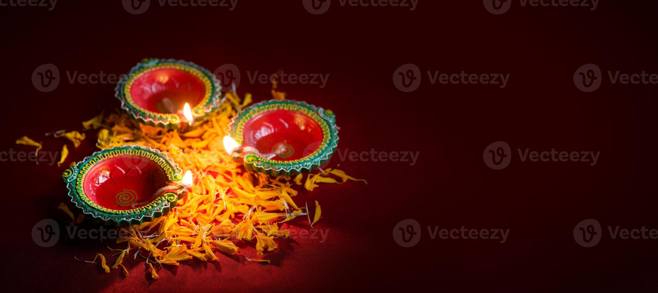 Happy Diwali - Clay Diya lamps lit during Diwali celebration. Greetings Card Design of Indian Hindu Light Festival called Diwali photo