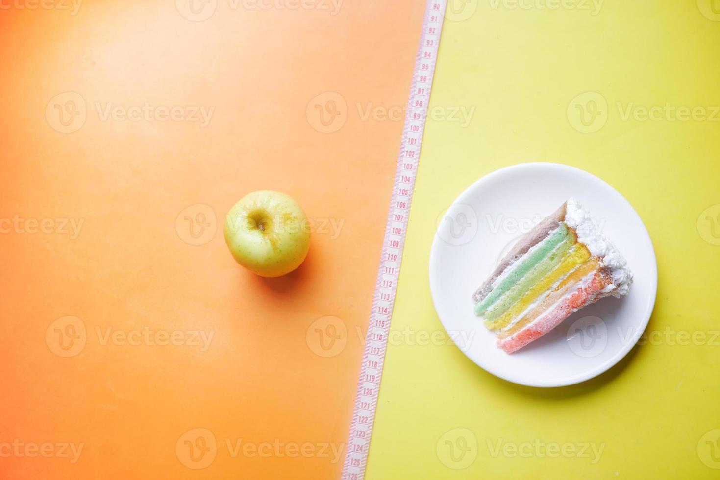 Cinta métrica, manzana verde y un pastel de panadería sobre fondo de color foto