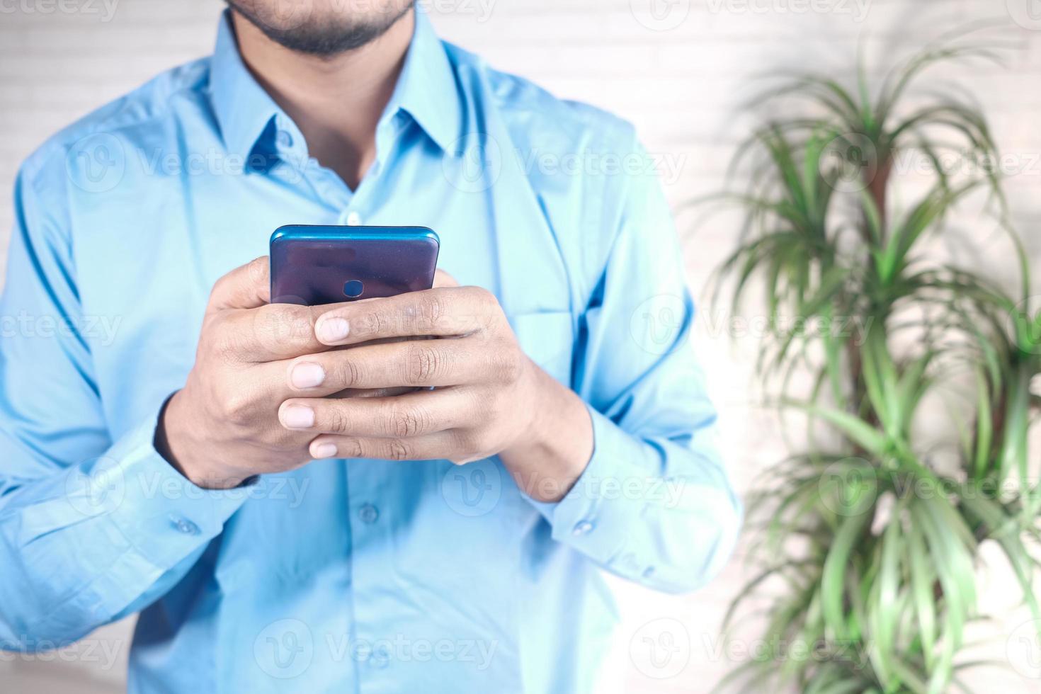 Close up of young man hand using smart phone. photo