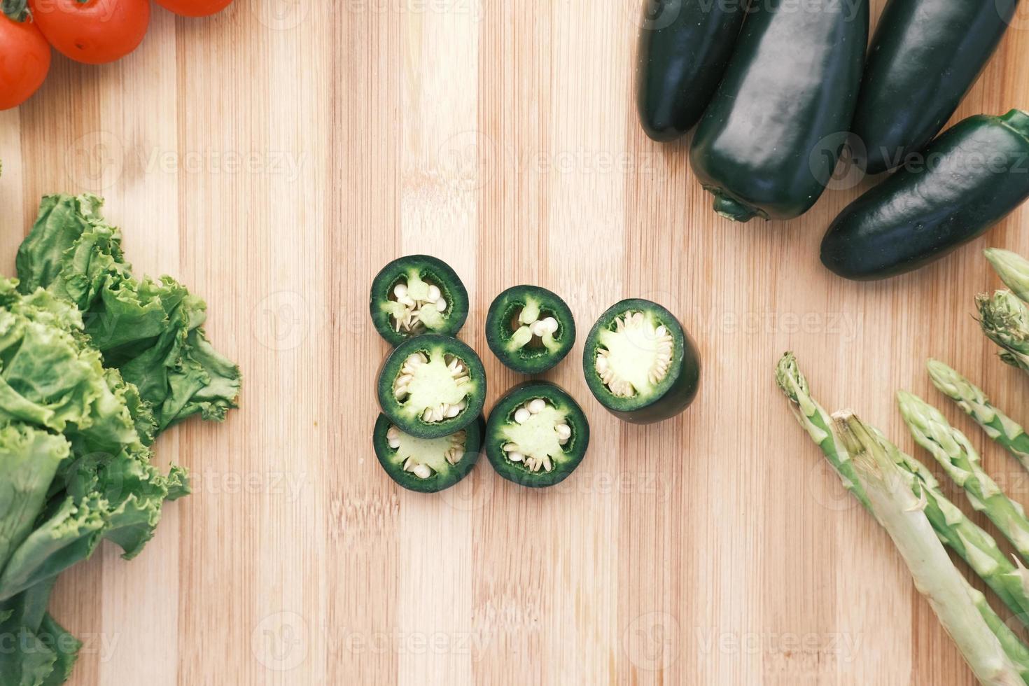 Jalapeno peppers , asparagus, cherry tomato, lettuce on chopping board photo