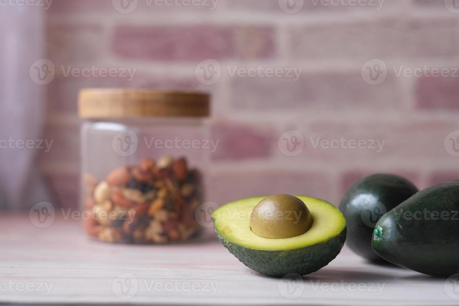 Cerca de una rodaja de aguacate y nueces mixtas sobre una tabla de cortar. foto