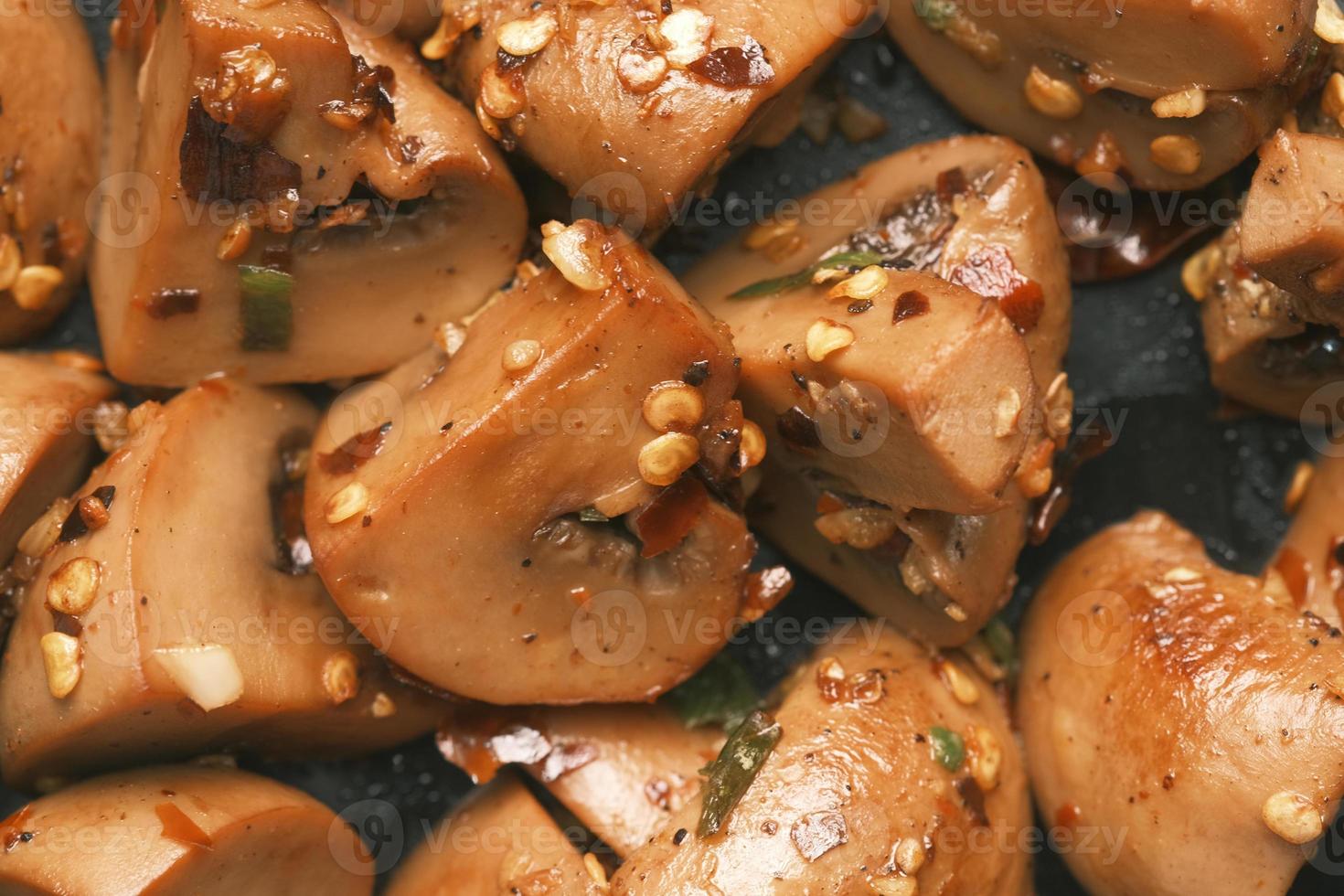 sauteed mushrooms with garlic and parsley on a black plate on table photo