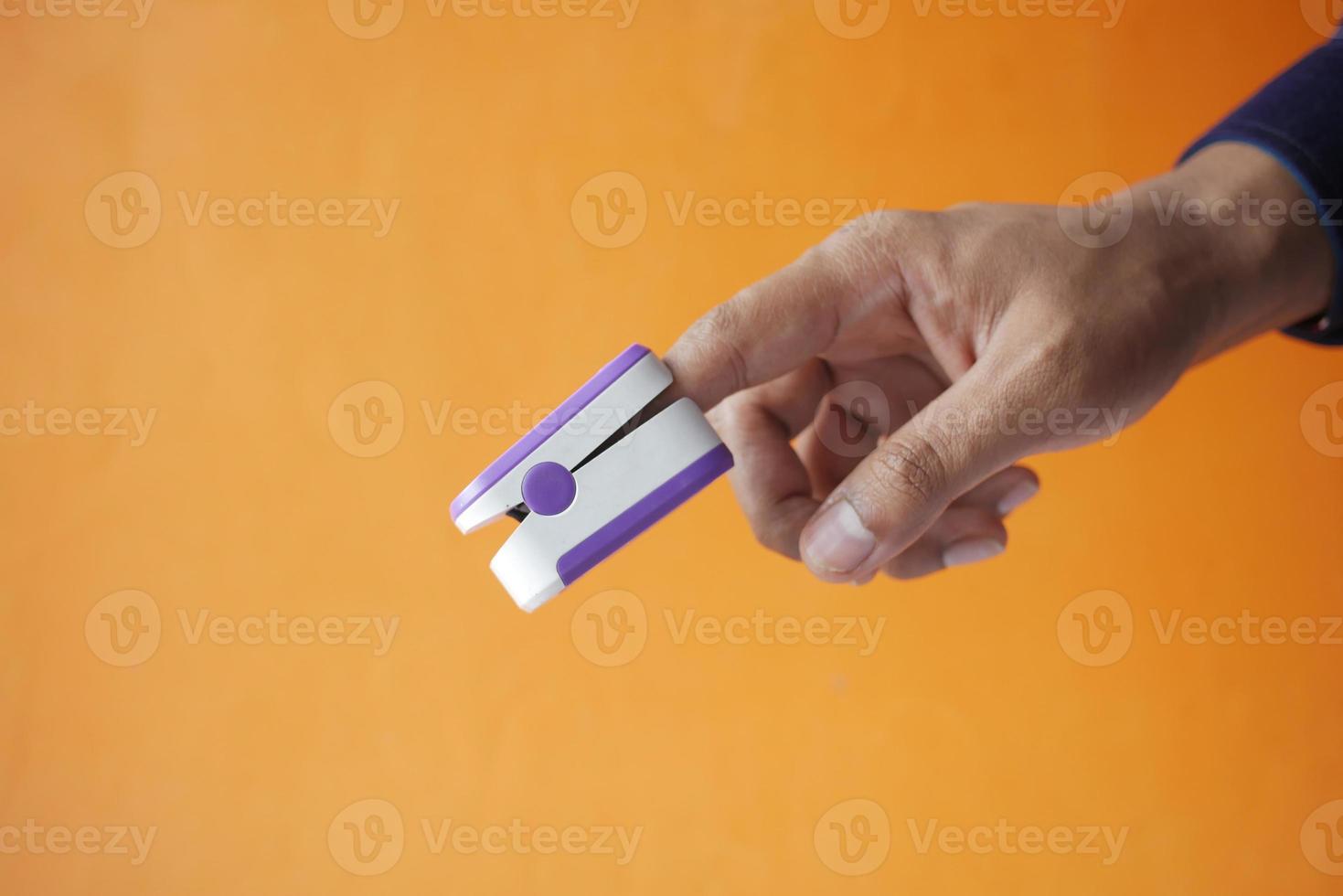 close up of man hand using pulse oximeter photo