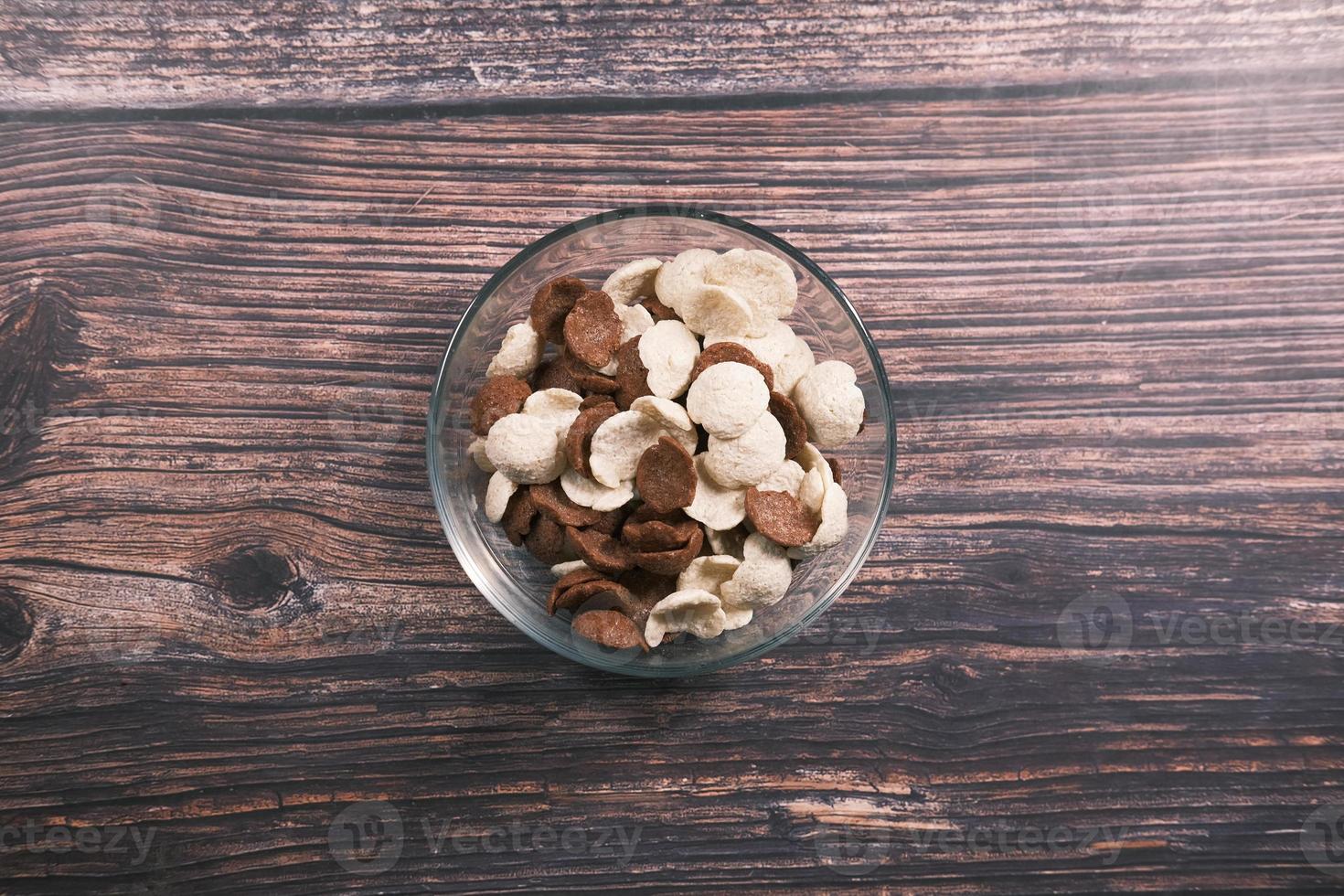 Top view of chocolate corn flakes in a bowl on wooden table photo