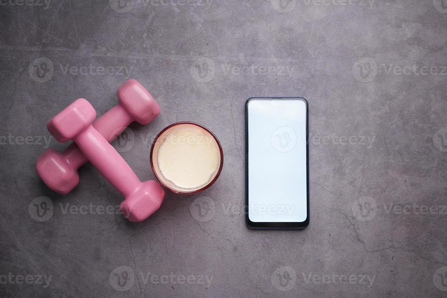 Smart phone with sports equipment on black background . photo