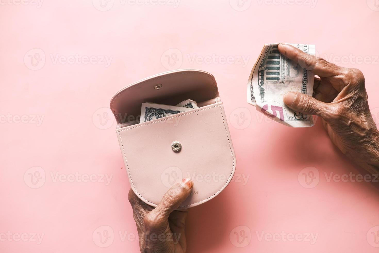 senior women hand saving cash in wallet photo