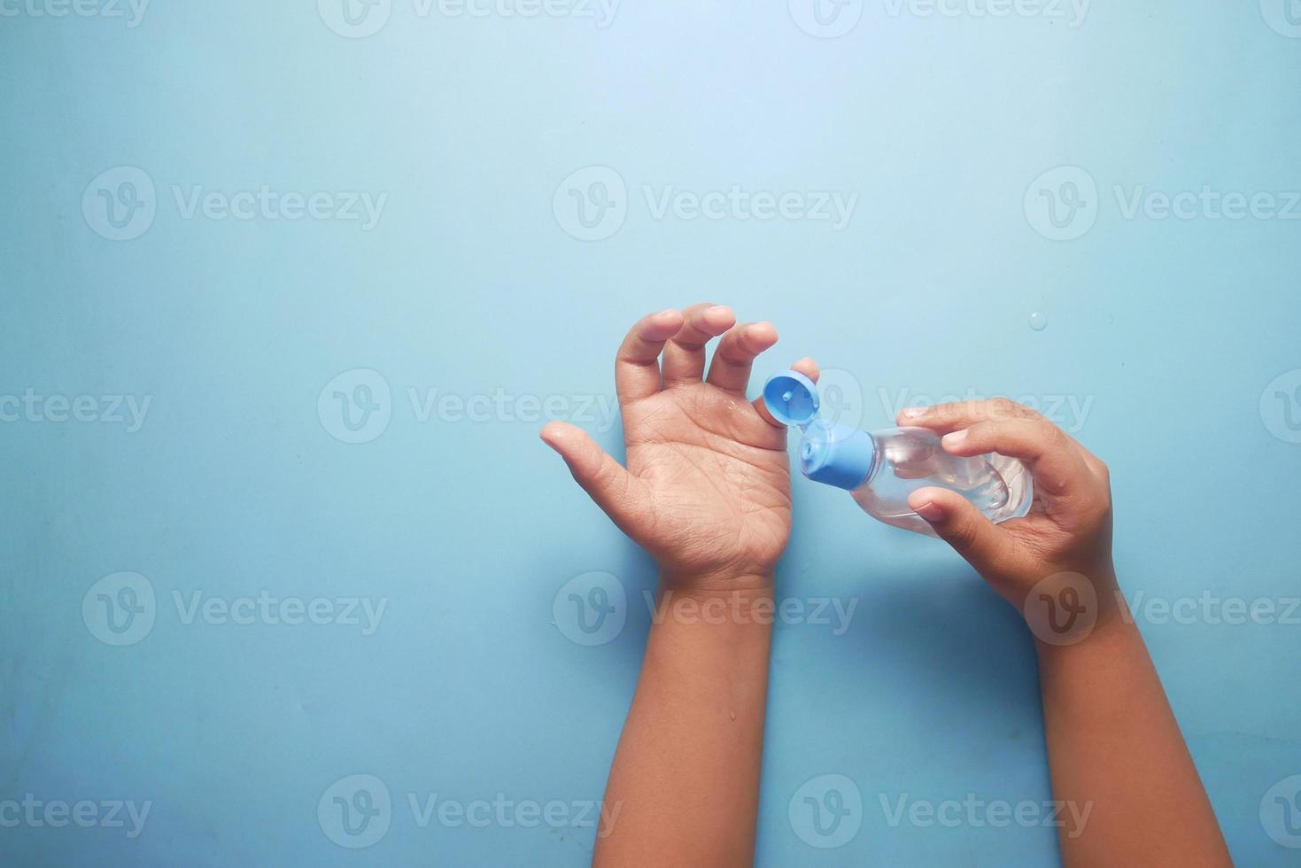 Mano de niño usando gel desinfectante para prevenir virus con espacio de copia foto