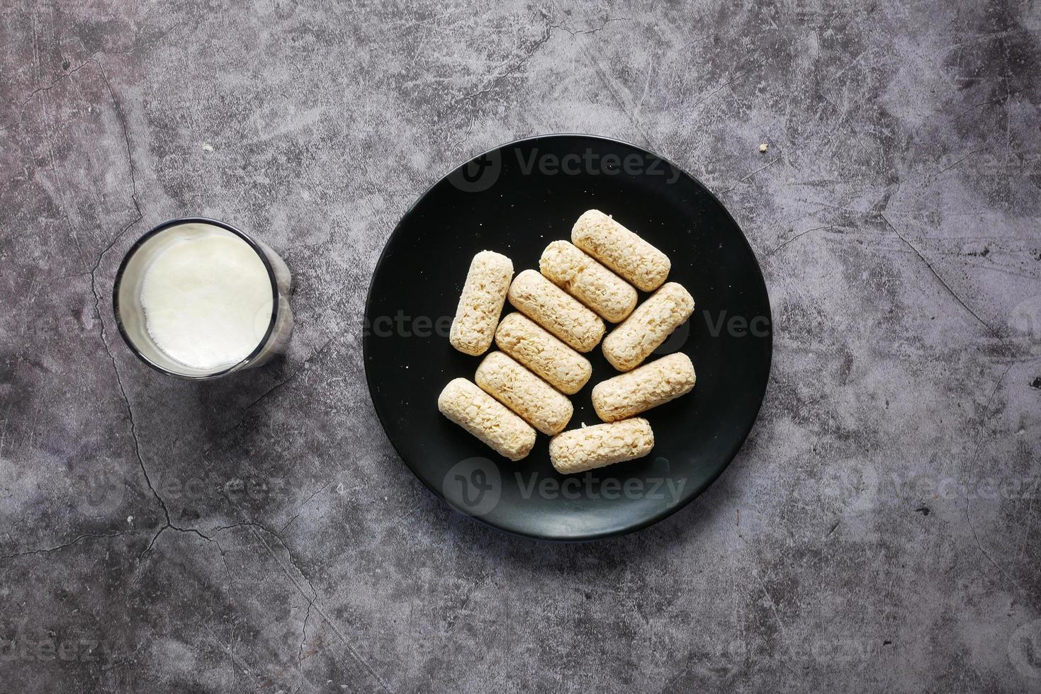 deliciosas barras de avena en un plato y un vaso de leche en la mesa, foto