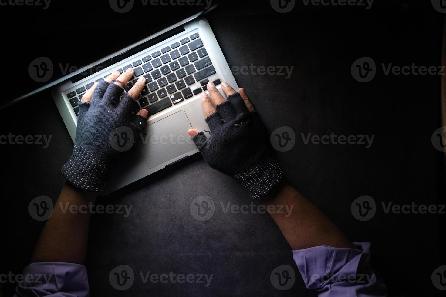 Mano de hacker robando datos de la computadora portátil de arriba hacia abajo foto