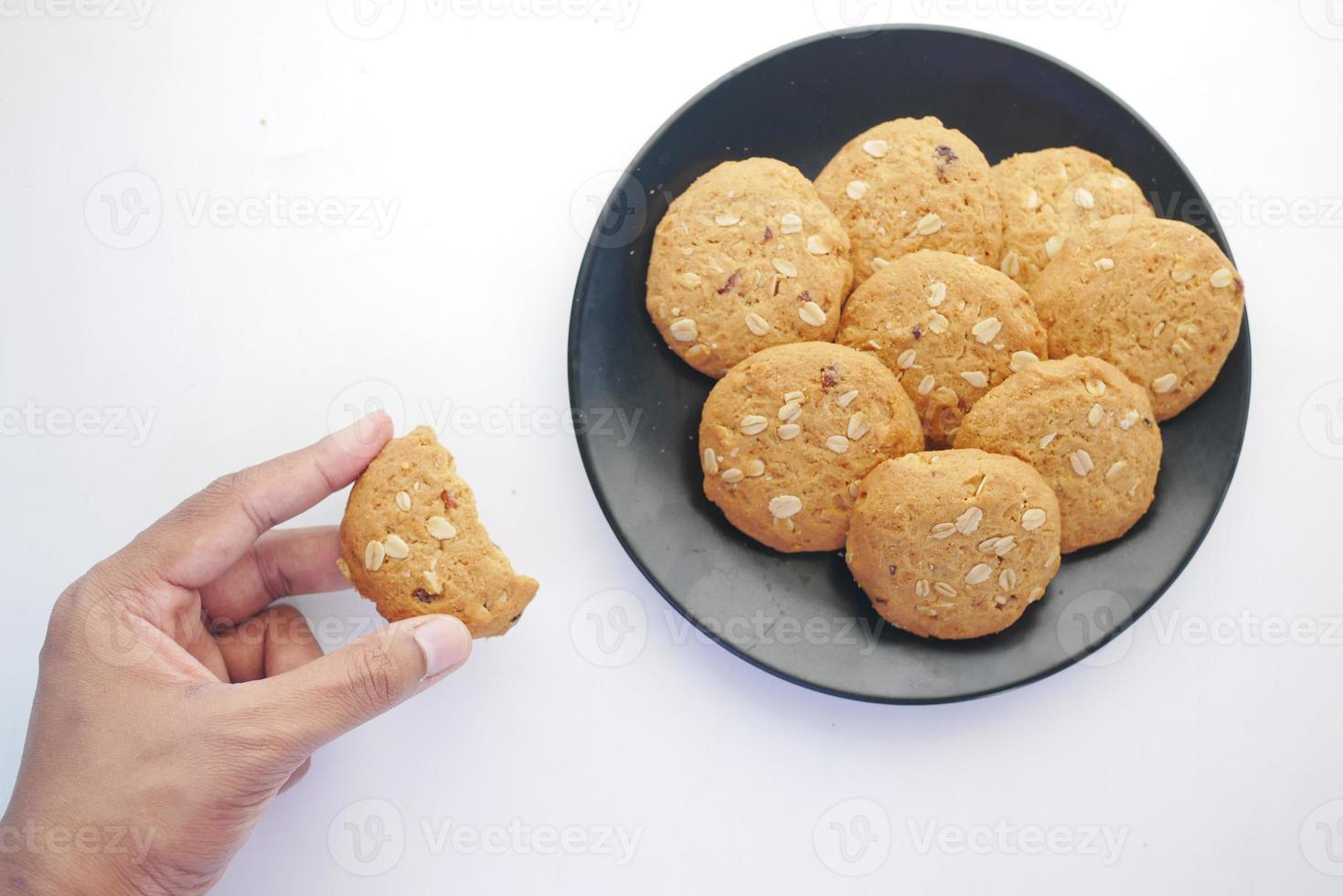 Recoger a mano galletas de comida entera sobre fondo de madera foto