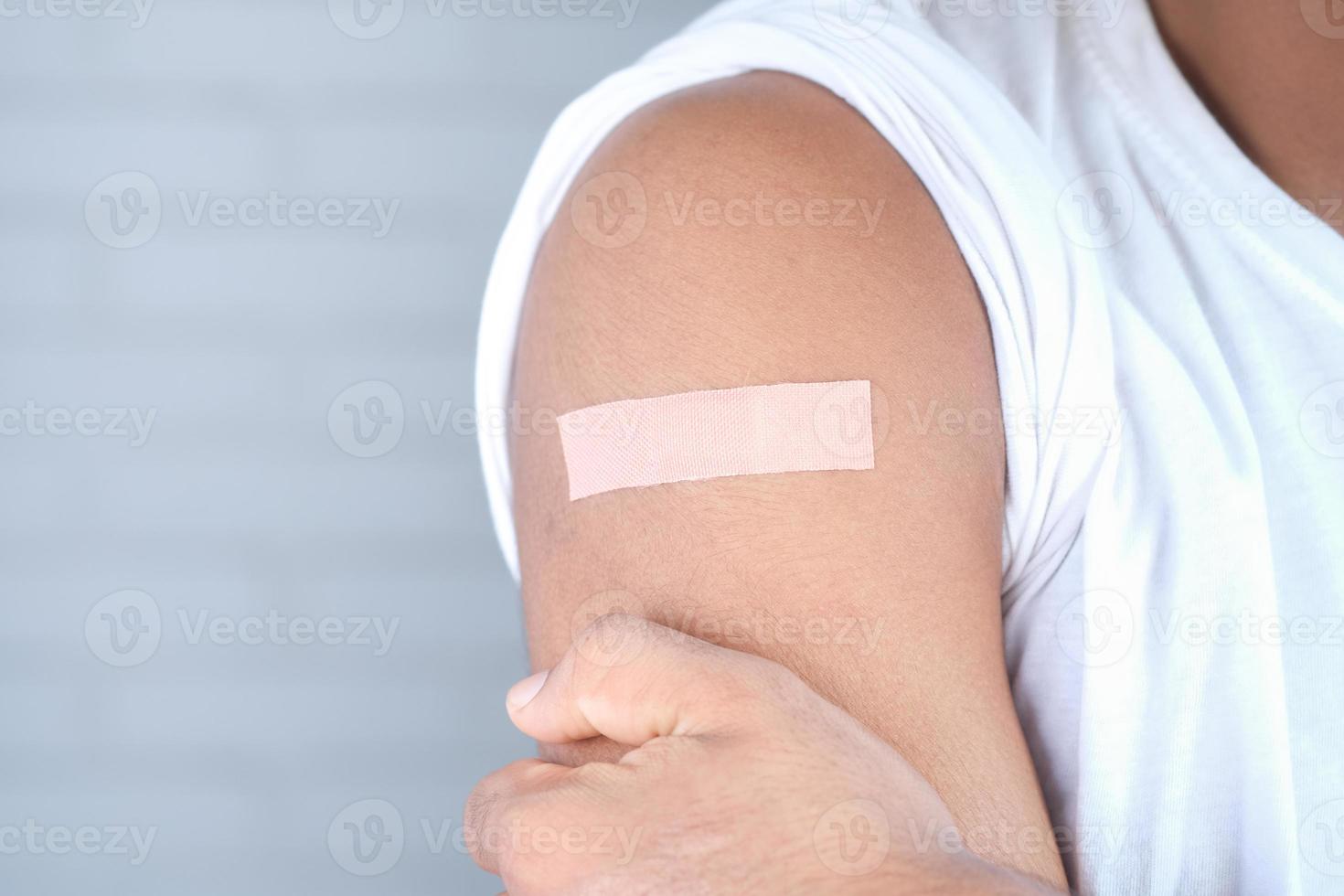 adhesive bandage on young man's arm photo