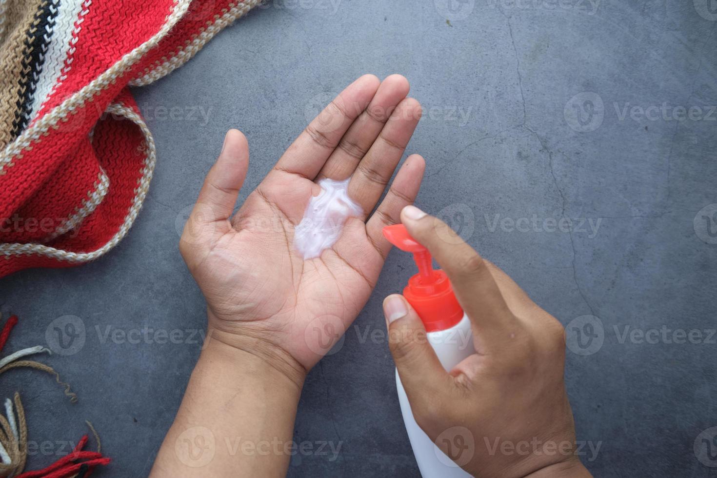 La mano del hombre con jabón líquido sobre fondo negro foto