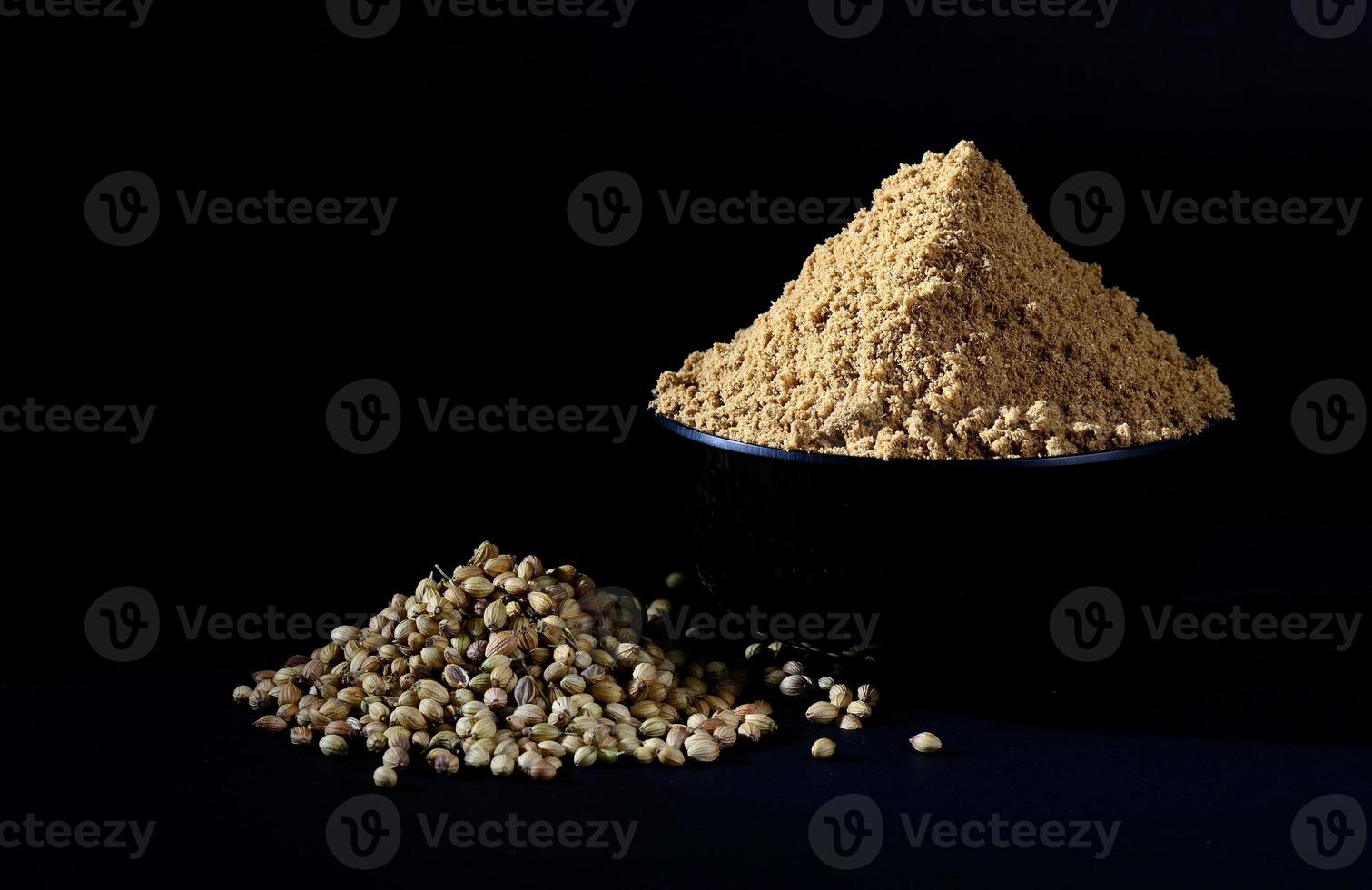 Coriander Powder and Coriander seeds on black background photo