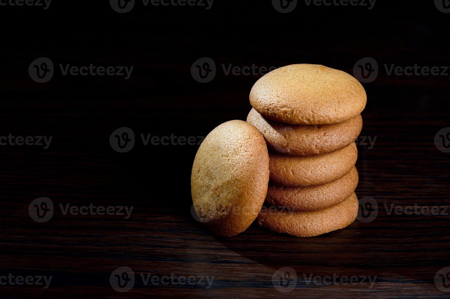 BISCUITS - Stack of delicious cream biscuits filled with chocolate cream on black background photo