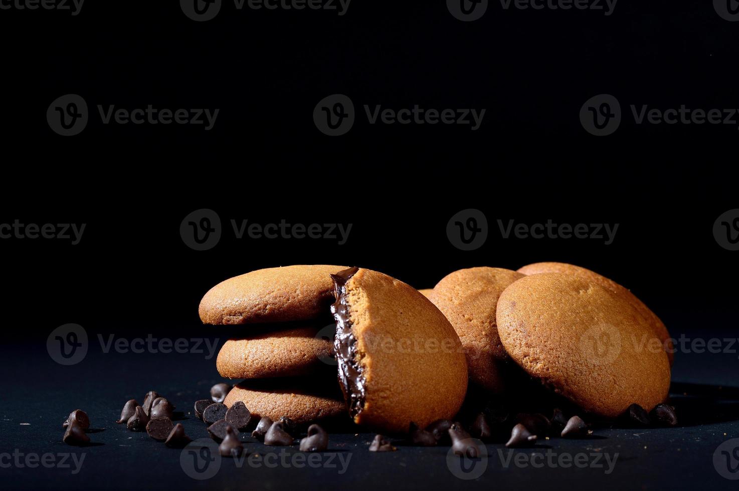 Biscuits filled with chocolate cream. Chocolate cream cookies. brown chocolate biscuits with cream filling on black background. photo