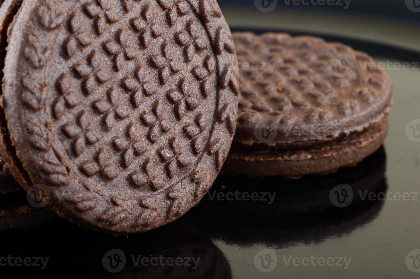 Galletas sandwich de chocolate marrón con relleno de crema en la placa foto