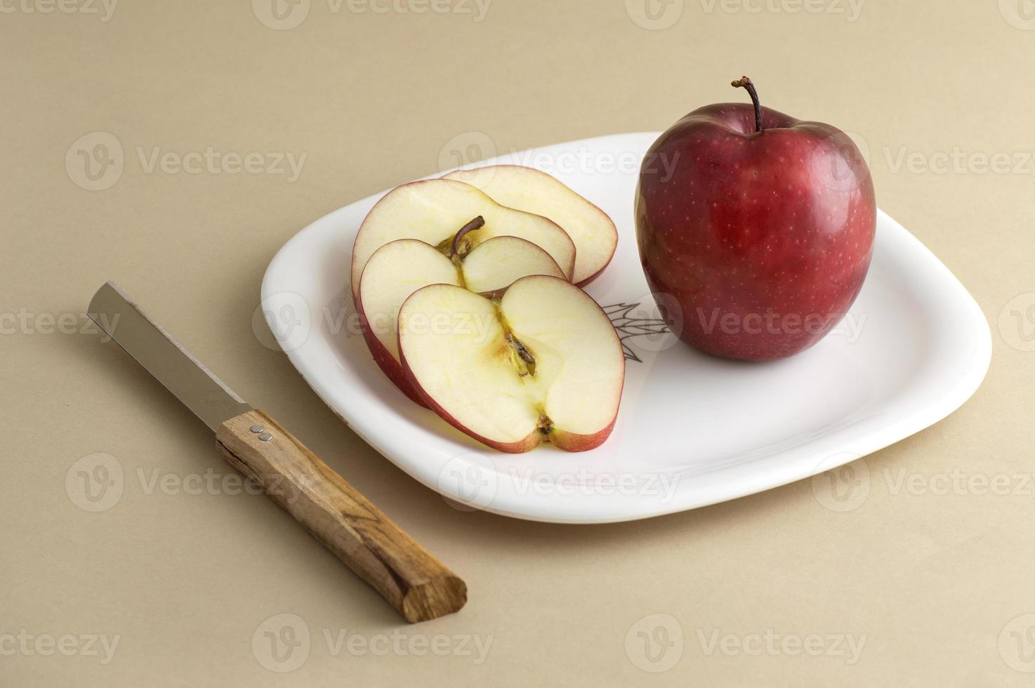 Deliciosa manzana y rebanada en plato blanco con cuchillo y tenedor foto