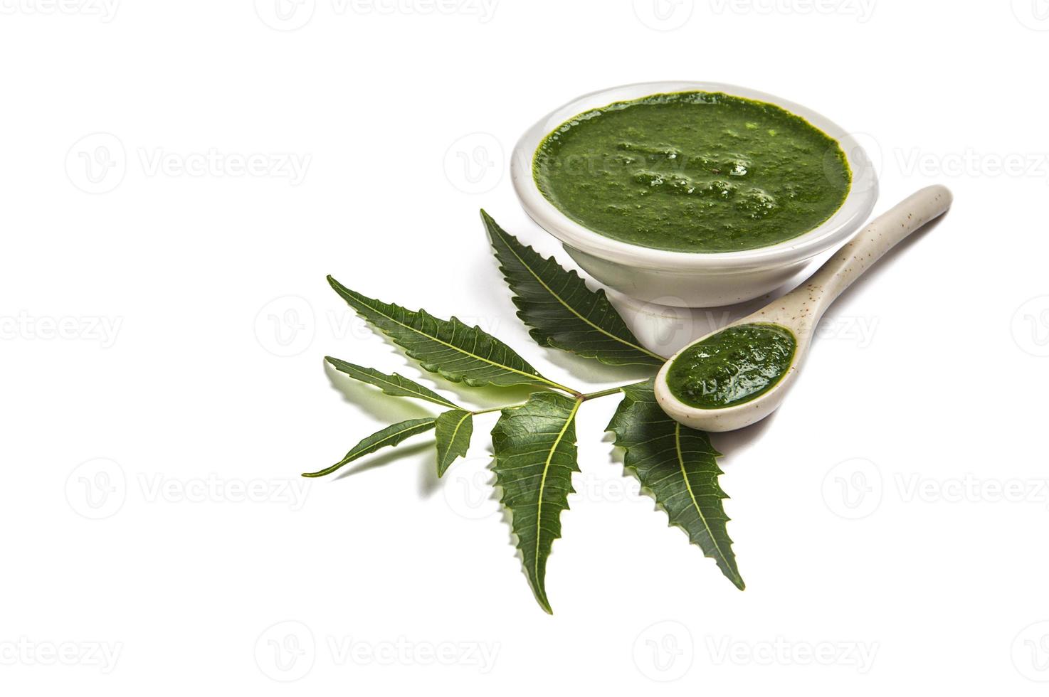Medicinal Neem leaves with neem paste in spoon and plate on white background Azadirachta indica photo